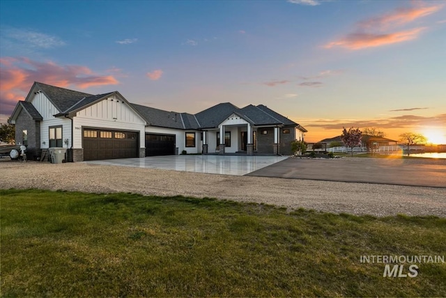 modern farmhouse style home featuring board and batten siding, an attached garage, driveway, and a lawn