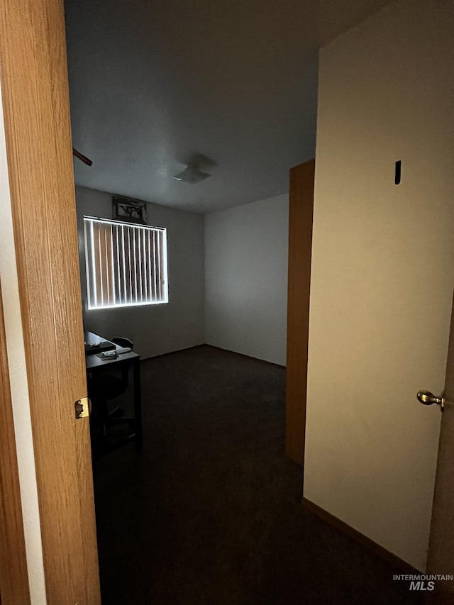 spare room with dark colored carpet