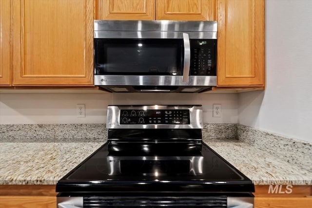 kitchen featuring appliances with stainless steel finishes and light stone counters