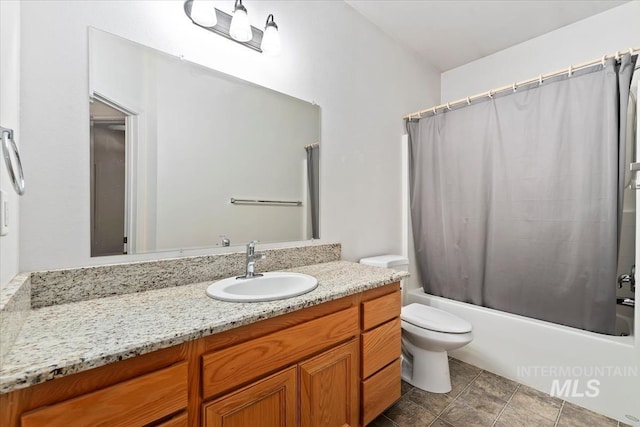 full bathroom with vanity, shower / tub combo, and toilet