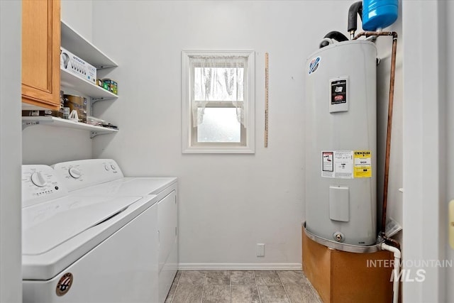 laundry room with cabinets, independent washer and dryer, and electric water heater