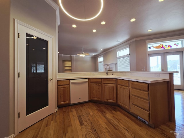 1203 Tara Ct, Fruitland, ID 83619 - kitchen with brown cabinets, a sink, dishwasher, ornamental molding, and dark wood-style floors