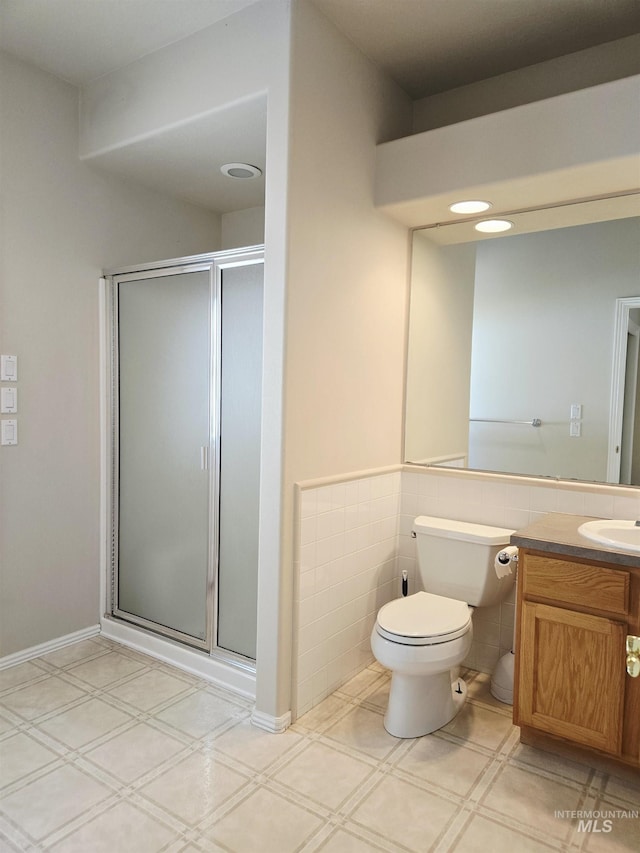 1203 Tara Ct, Fruitland, ID 83619 - full bathroom with tile walls, a stall shower, vanity, a wainscoted wall, and toilet