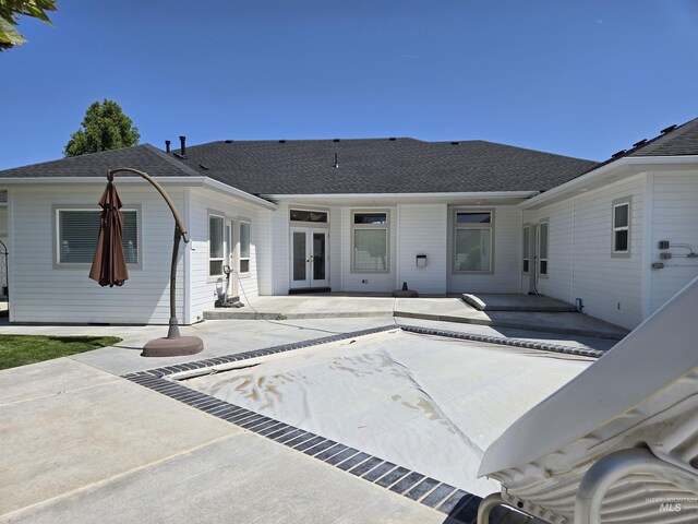 1203 Tara Ct, Fruitland, ID 83619 - rear view of property with a patio, roof with shingles, and french doors