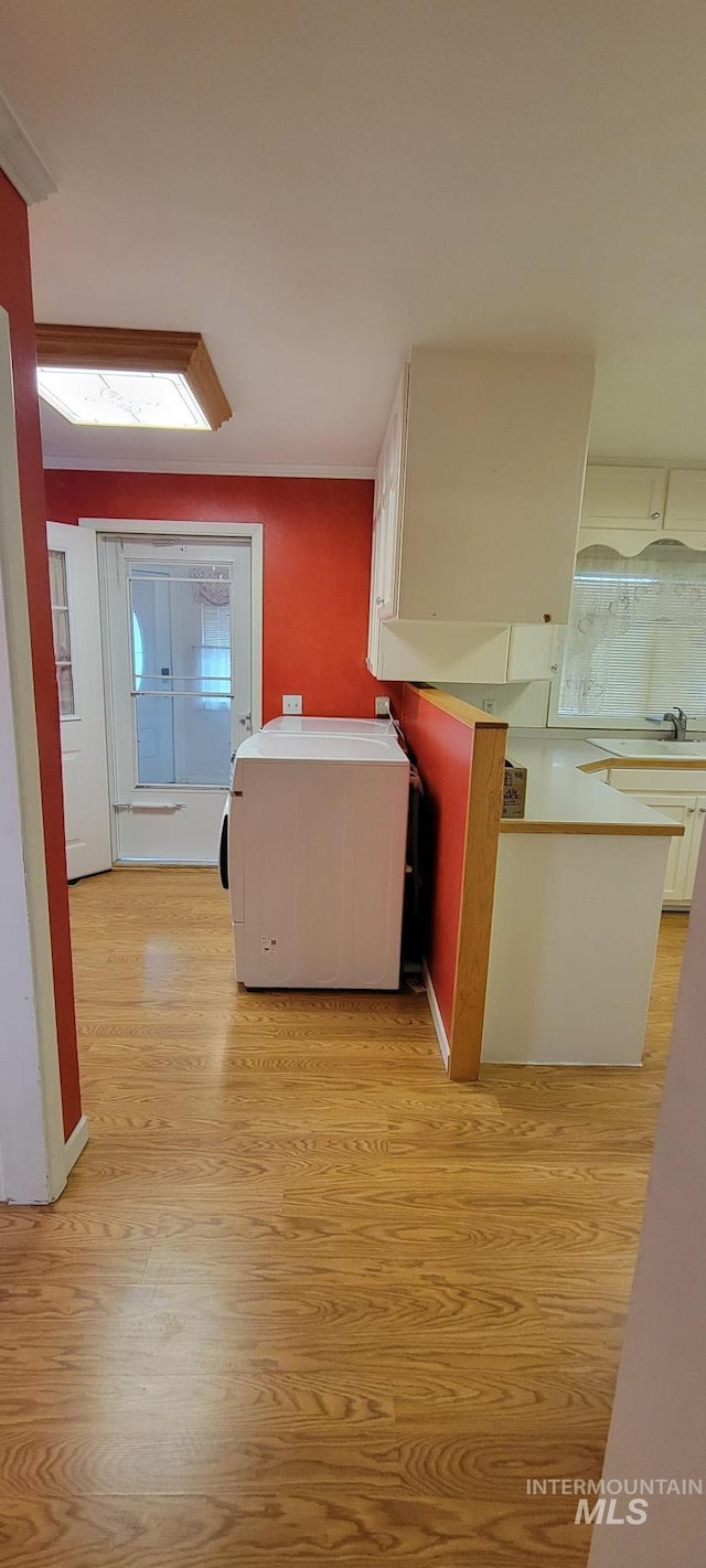 hallway with light wood-type flooring and washer / clothes dryer