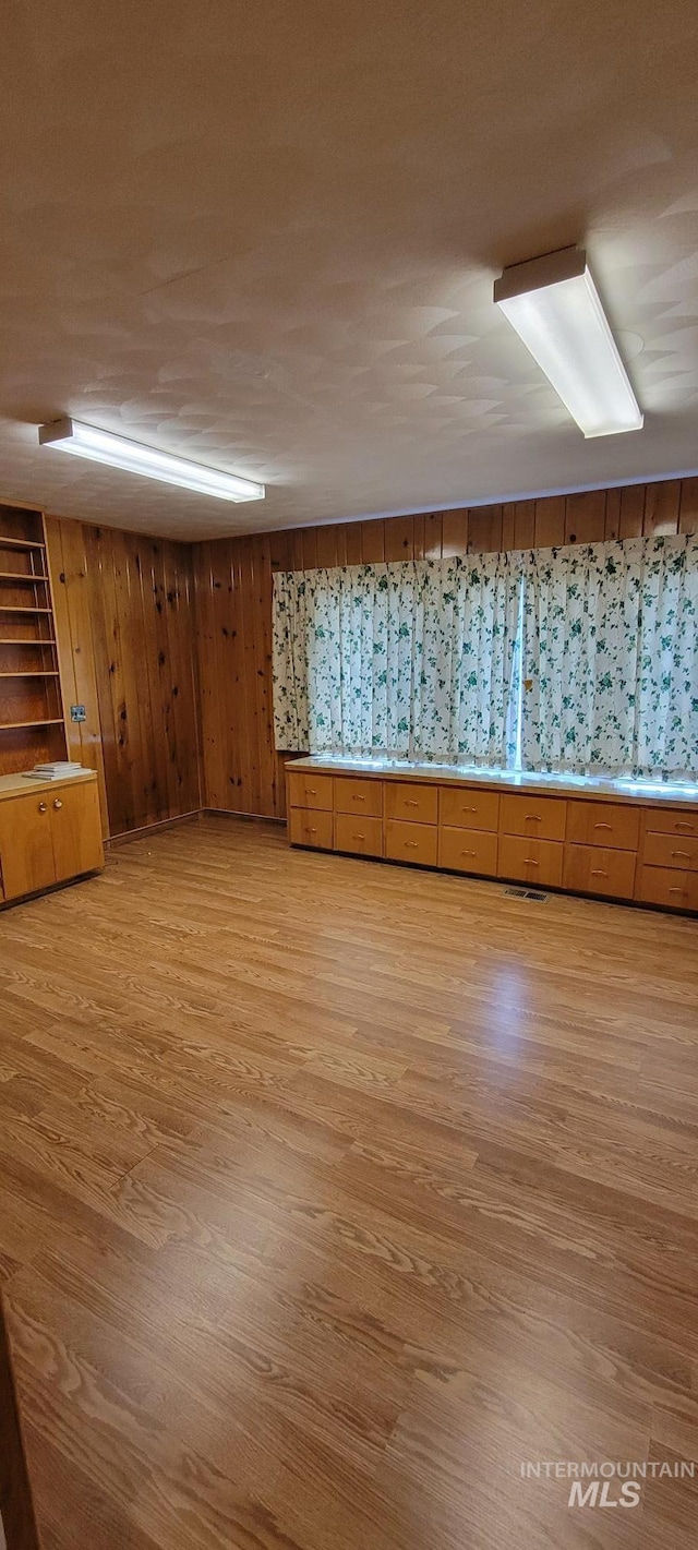 interior space with wooden walls and light wood-style flooring