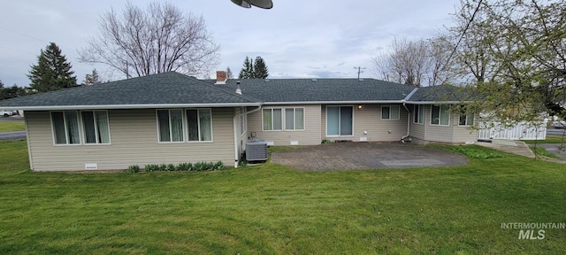 back of property featuring central AC, a chimney, a lawn, a patio, and roof with shingles