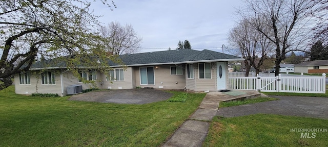 view of front facade featuring a gate, fence, a front lawn, central AC, and a patio