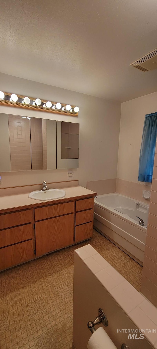 full bathroom with a bath, visible vents, tile patterned floors, and vanity