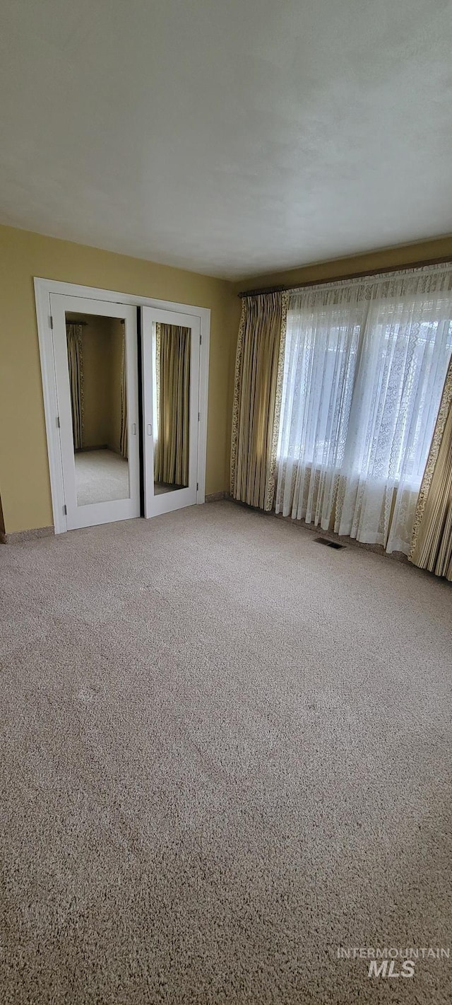 carpeted spare room featuring visible vents