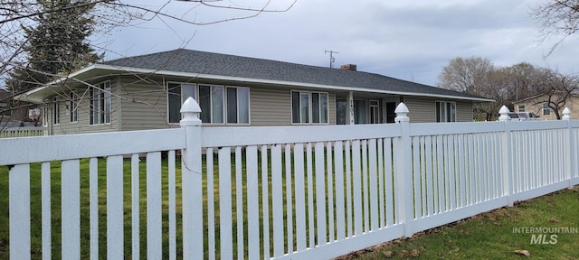 view of side of property with fence and a yard