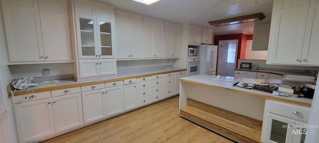 kitchen featuring white cabinets, white appliances, and light countertops