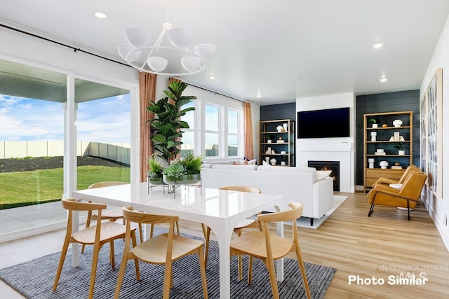 dining room with light wood-type flooring and an inviting chandelier