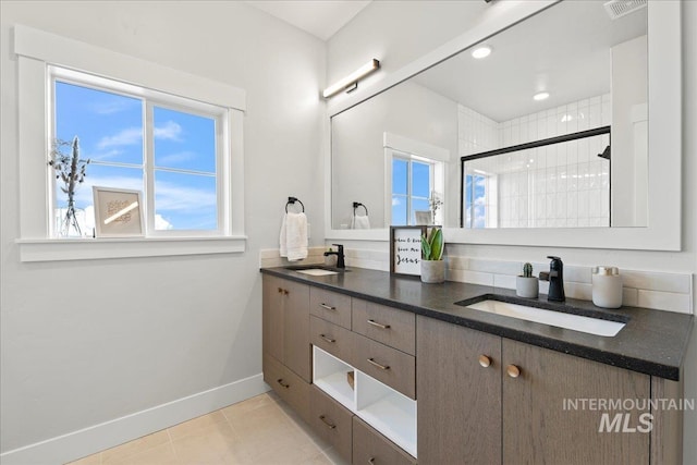 bathroom featuring vanity, a tile shower, and tile patterned floors