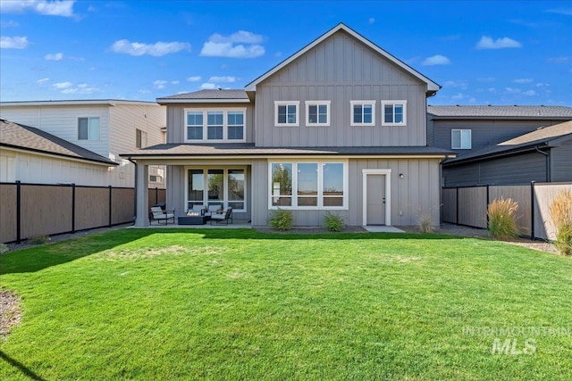 rear view of property with an outdoor hangout area, a patio area, and a lawn