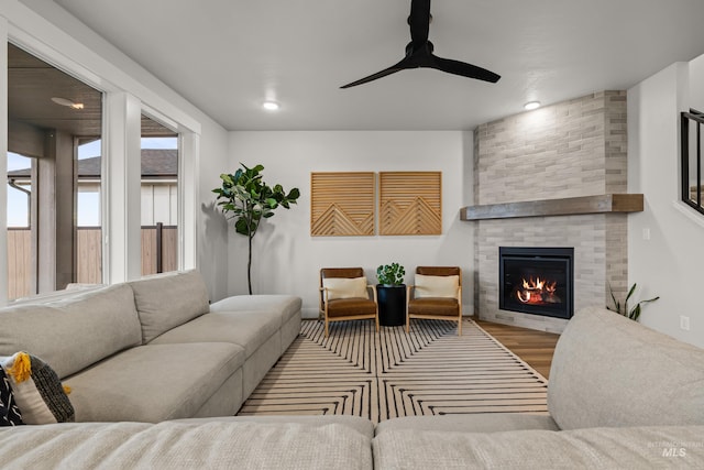 living room featuring hardwood / wood-style flooring, a fireplace, and ceiling fan