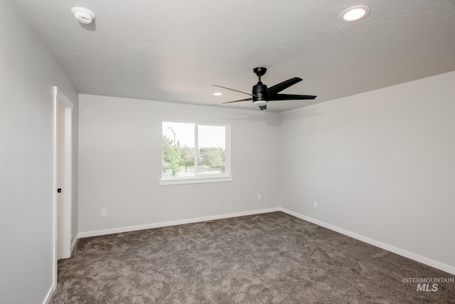 carpeted spare room featuring ceiling fan