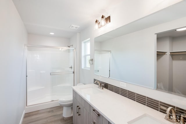 bathroom featuring hardwood / wood-style floors, toilet, an enclosed shower, and vanity