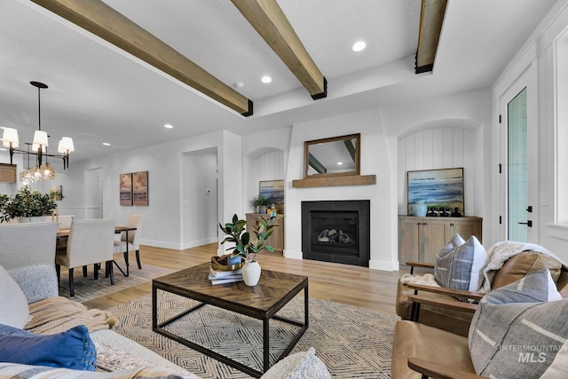 living room featuring light wood-type flooring, beamed ceiling, recessed lighting, a fireplace, and baseboards