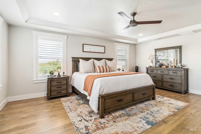 9115 S Palena Ave, Kuna, ID 83634 - bedroom with a tray ceiling, light wood-style floors, baseboards, ceiling fan, and recessed lighting
