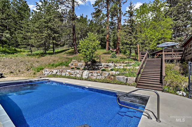 10 Daggett Rim, Boise, ID 83716 - swimming pool with stairs, view of wooded area, and a wooden deck