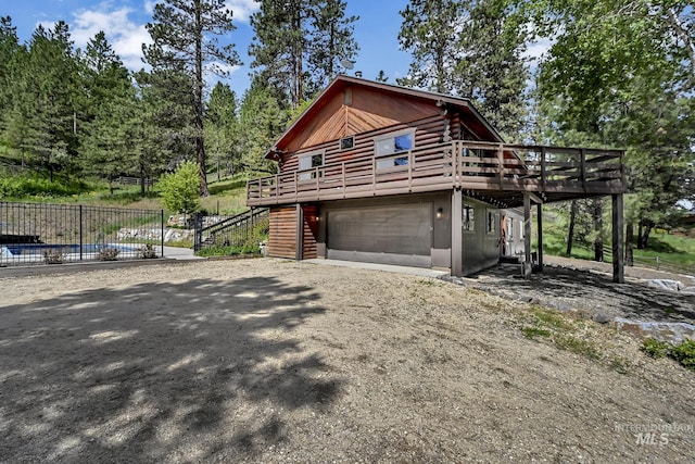 10 Daggett Rim, Boise, ID 83716 - view of property exterior with stairway, log siding, a wooden deck, dirt driveway, and an attached garage