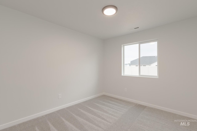 unfurnished room with light colored carpet, visible vents, and baseboards