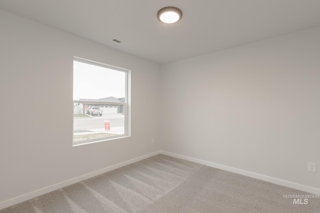 unfurnished room featuring light carpet, baseboards, and visible vents