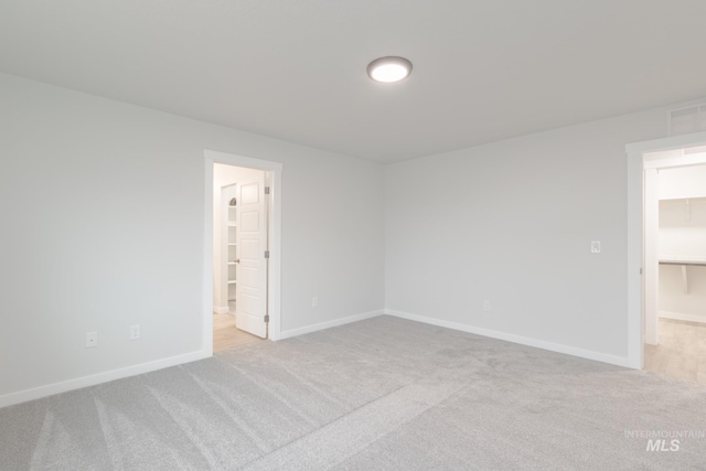 spare room with baseboards and carpet flooring