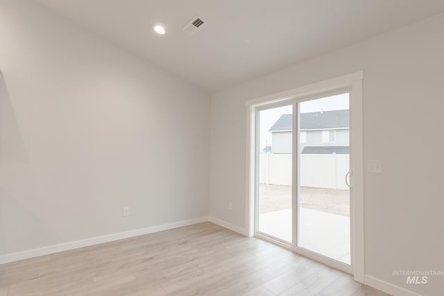 empty room featuring baseboards, light wood-type flooring, visible vents, and recessed lighting