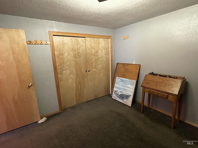 unfurnished bedroom with a closet, a textured ceiling, carpet, and a textured wall