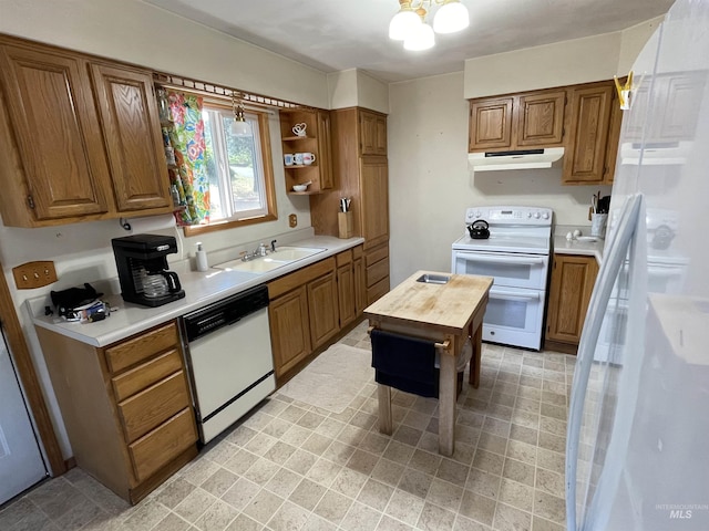 kitchen with under cabinet range hood, white appliances, brown cabinets, and a sink