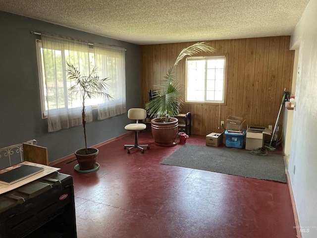 miscellaneous room with tile patterned floors, wood walls, a textured ceiling, and baseboards