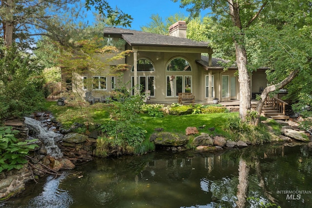 rear view of property featuring a water view