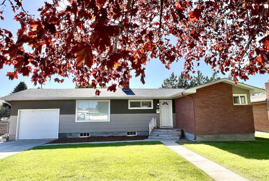 single story home with an attached garage, a front lawn, and driveway