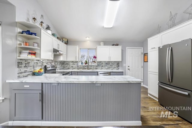 1003 Lauren Ln, Filer, ID 83328 - kitchen with tasteful backsplash, under cabinet range hood, appliances with stainless steel finishes, a peninsula, and white cabinets