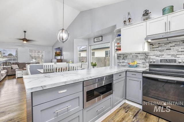 1003 Lauren Ln, Filer, ID 83328 - kitchen with gray cabinetry, under cabinet range hood, light stone counters, appliances with stainless steel finishes, and a peninsula