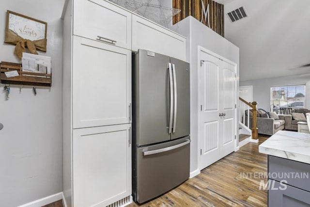 1003 Lauren Ln, Filer, ID 83328 - kitchen with visible vents, wood finished floors, freestanding refrigerator, white cabinets, and light countertops
