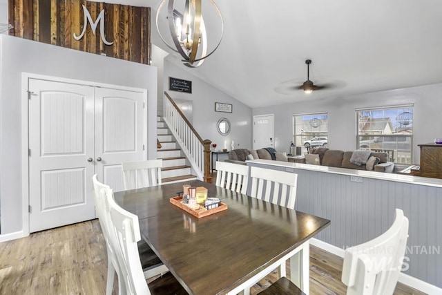 1003 Lauren Ln, Filer, ID 83328 - dining area featuring stairway, baseboards, vaulted ceiling, light wood-style floors, and ceiling fan with notable chandelier
