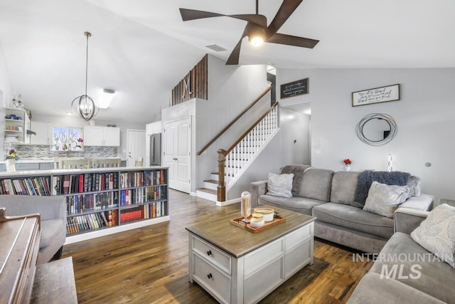 1003 Lauren Ln, Filer, ID 83328 - living room with stairway, a ceiling fan, visible vents, dark wood-style flooring, and vaulted ceiling