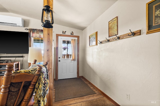 doorway featuring baseboards, a wall unit AC, and lofted ceiling