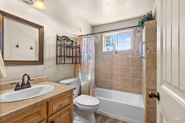 full bath featuring a textured wall, shower / bath combo, vanity, toilet, and wood finished floors