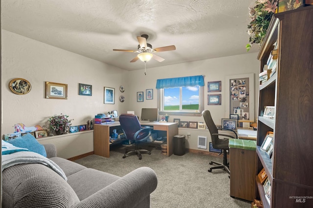 carpeted office with a ceiling fan and baseboards