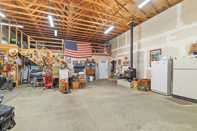 garage with freestanding refrigerator and a wood stove