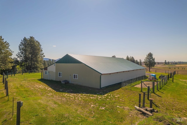 view of home's exterior with a yard, fence, and an outbuilding