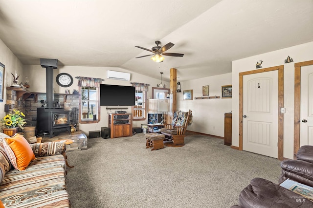 carpeted living room with a wood stove, baseboards, a wall mounted AC, a ceiling fan, and vaulted ceiling
