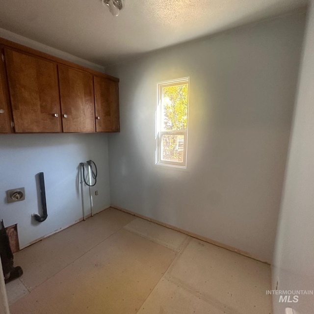 washroom with hookup for an electric dryer and cabinets