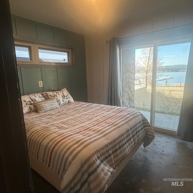 bedroom featuring a water view and access to exterior