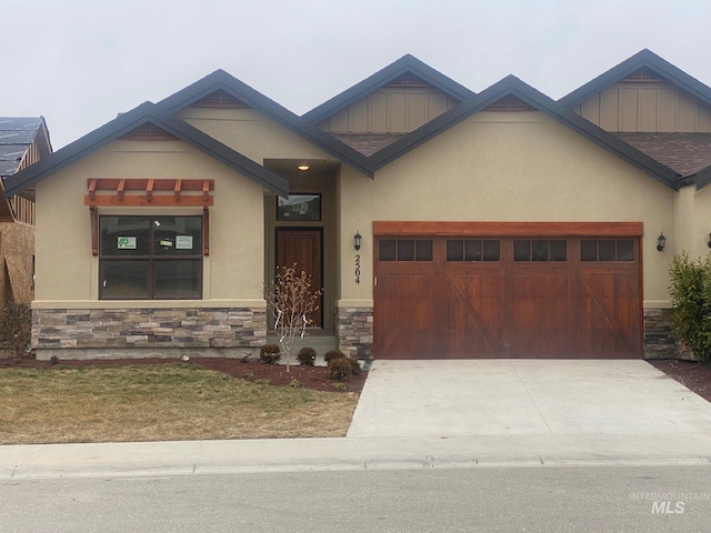 2504 E Hidden Creek St, Nampa, ID 83687 - view of front facade featuring stone siding, an attached garage, stucco siding, driveway, and board and batten siding