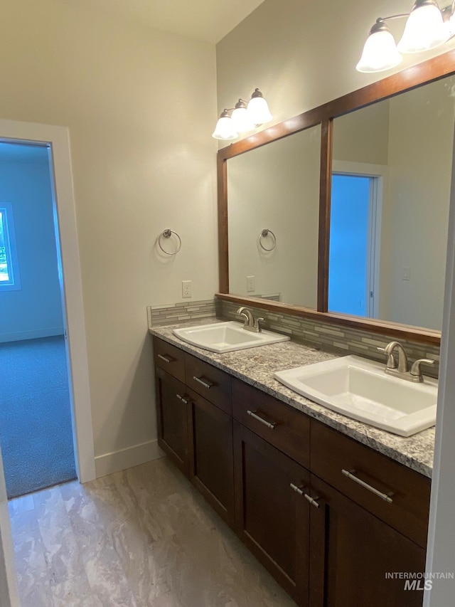 2504 E Hidden Creek St, Nampa, ID 83687 - bathroom with double vanity, baseboards, and marble look tiles